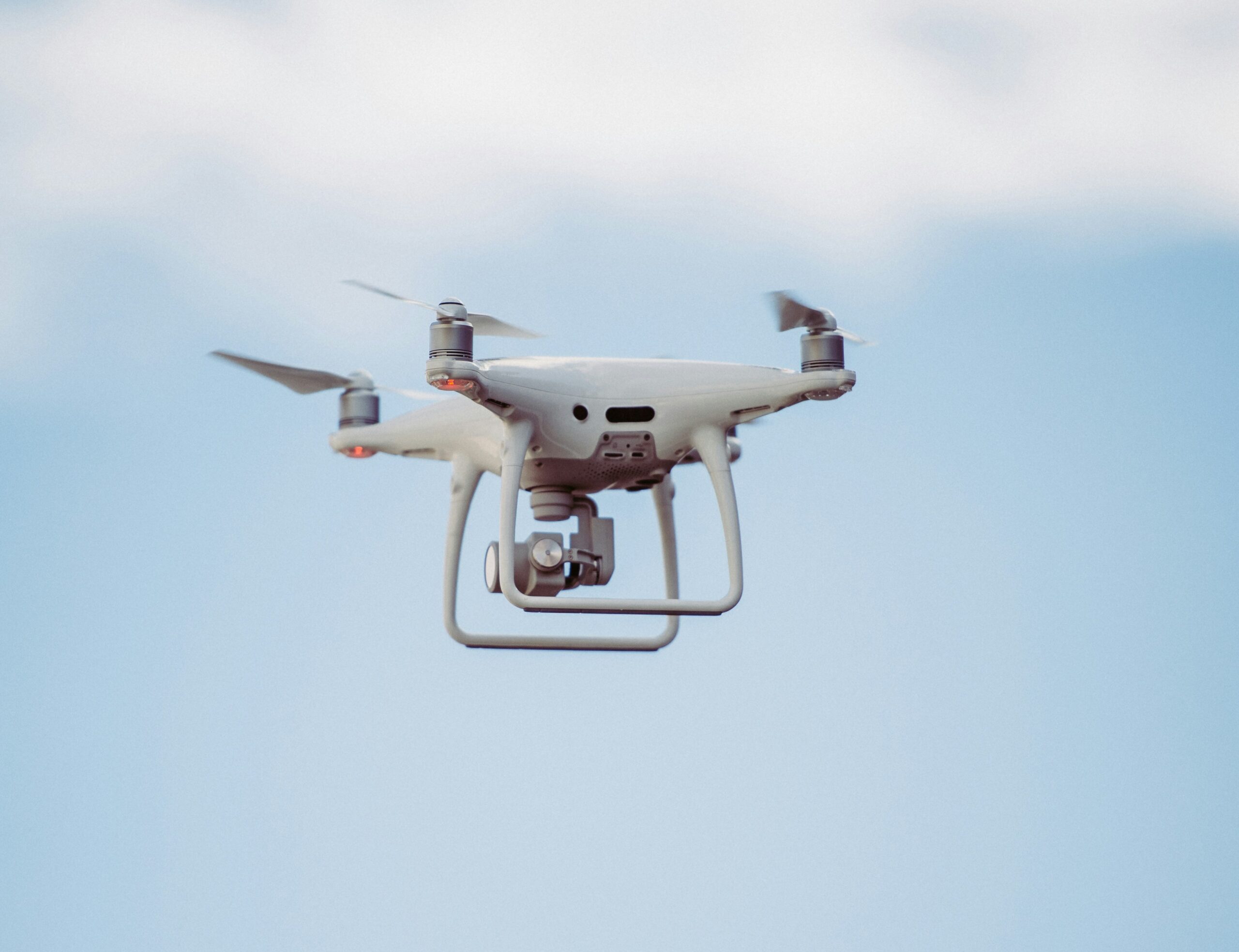 A drone in flight against a clear sky background.